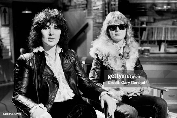 View of American siblings & Rock musicians Ann Wilson and Nancy Wilson, both of the group Heart, seated in director's chairs during an interview on...