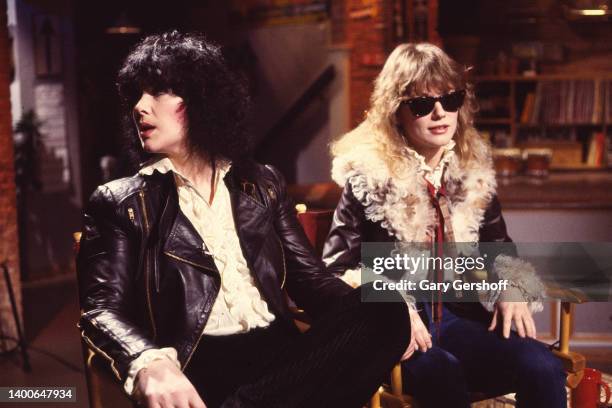 View of American siblings & Rock musicians Ann Wilson and Nancy Wilson, both of the group Heart, seated in director's chairs during an interview on...