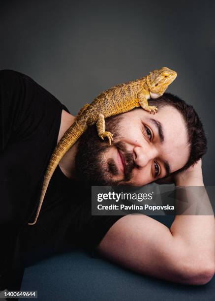 portrait of a men with his pet bearded dragon - baardagame stockfoto's en -beelden