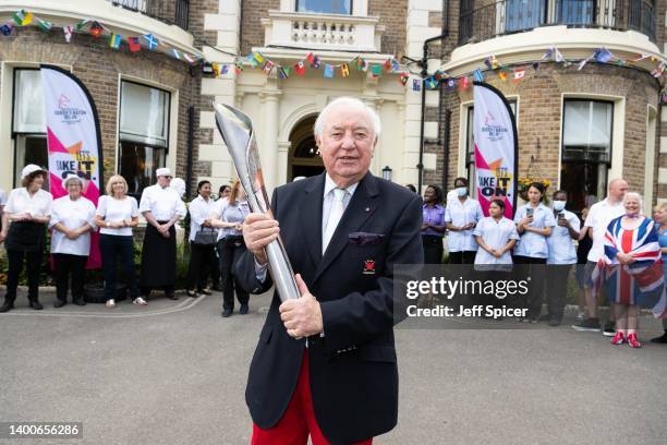 Batonbearer Jimmy Tarbuck holds the Queen’s Baton during the Birmingham 2022 Queen's Baton Relay at a visit to Brinsworth House in Twickenham on June...