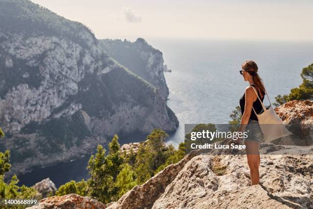 vacation hiker looks out at beautiful sea view in ibiza - ibiza island stock pictures, royalty-free photos & images