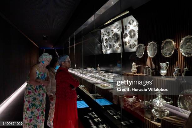 Visitors watch silverware on display at the Royal Treasure Museum in Ajuda National Palace on June 02, 2022 in Lisbon, Portugal. The Museu do Tesouro...