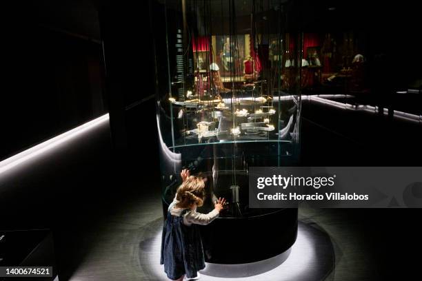 Child plays by the showcase housing gold nuggets at the Royal Treasure Museum in Ajuda National Palace on June 02, 2022 in Lisbon, Portugal. The...