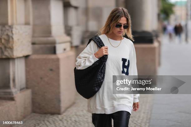 Alessa Winter wearing black Bottega Veneta Jodie bag, white Half boy sweater, black Samsoe Samsoe pants and Ray Ban shades on May 31, 2022 in Berlin,...