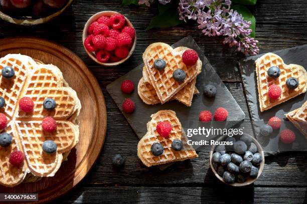 waffeln mit beerenfrüchten auf dunklem holztisch - waffel kuchen und süßwaren stock-fotos und bilder