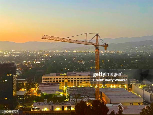 construction crane high up above universal city, los angeles - angle photos et images de collection
