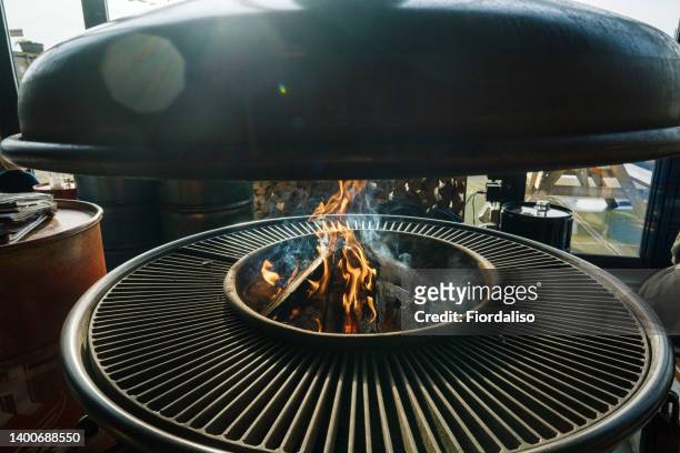 round hearth for cooking. brazier, barbecue in a restaurant for frying meat and vegetables on an open fire - brasero photos et images de collection