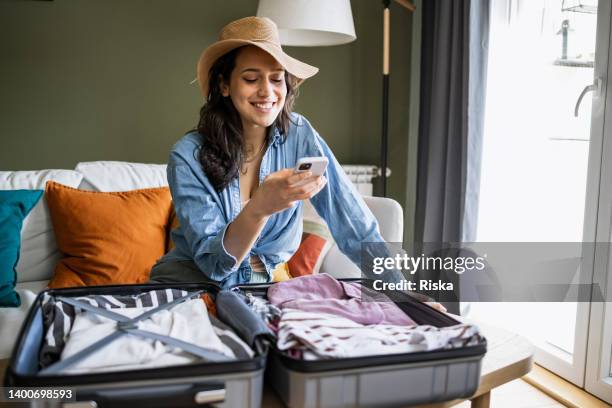 ritratto di donna che indossa un cappello di paglia e fa le valigie per un viaggio - one young woman only foto e immagini stock