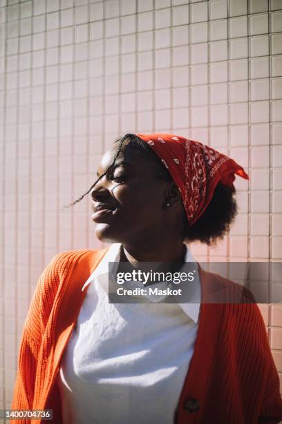 smiling woman wearing bandana standing with eyes closed during sunny day - black bandana stock pictures, royalty-free photos & images