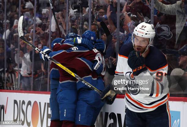 Mikko Rantanen of the Colorado Avalanche celebrates with his teammates in front of Connor McDavid of the Edmonton Oilers after scoring a goal on Mike...