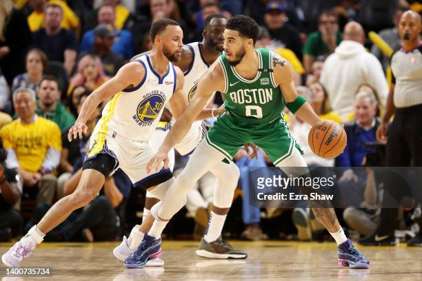 Jayson Tatum of the Boston Celtics dribbles against Stephen Curry of the Golden State Warriors during the fourth quarter in Game One of the 2022 NBA...