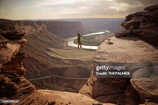 slack-lining des centaines de pieds au-dessus du canyon dans le parc moab, utah - canyon photos et images de collection