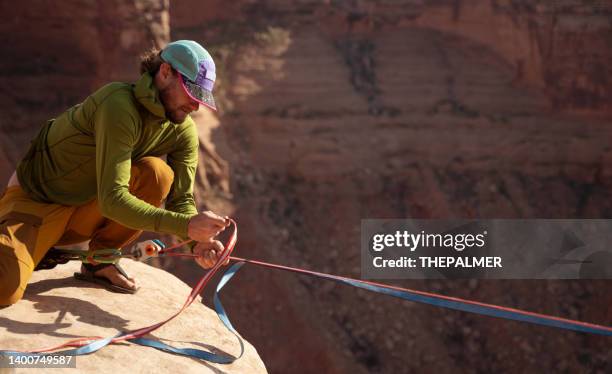 junger mann, der die seile im moab-park für hohe auskleidung setzt - highline stock-fotos und bilder
