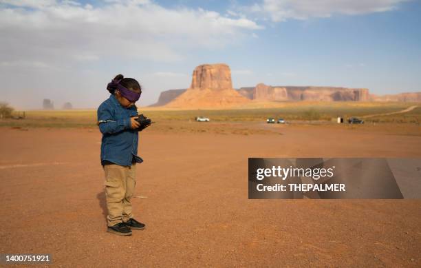 kid with remote control in his hands flying a drone in monument valley - rocky boys reservation stock pictures, royalty-free photos & images