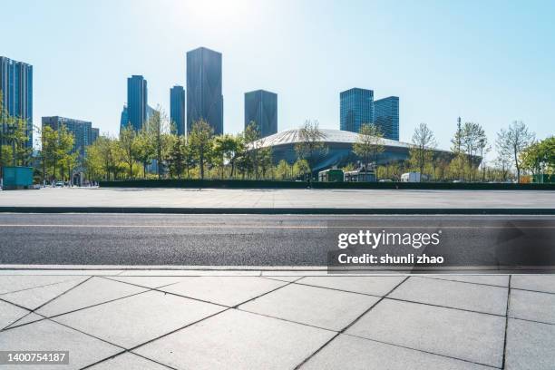 empty road against urban skyline - low angle view street stockfoto's en -beelden