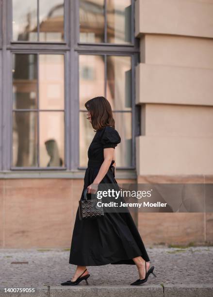 Lea Naumann wearing Prada black heels, black midi dress, Dior black Lady bag on May 31, 2022 in Berlin, Germany.