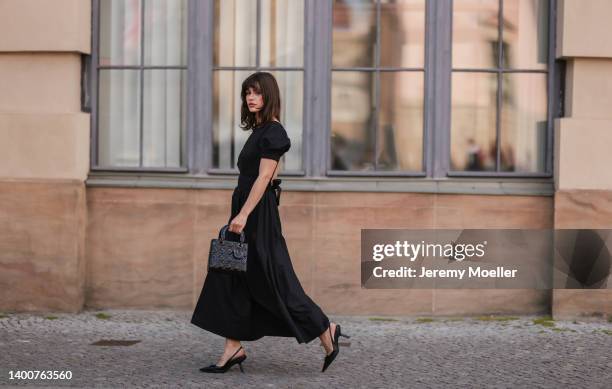 Lea Naumann wearing Prada black heels, black midi dress, Dior black Lady bag on May 31, 2022 in Berlin, Germany.