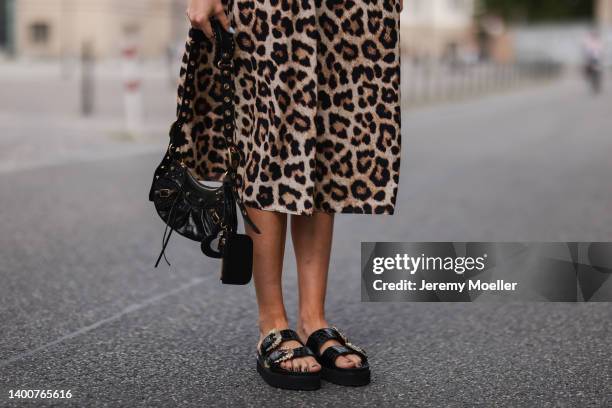 Celine Bethmann wearing Versace Jeans couture black gold sandals, Zara animal print dress and Balenciaga Le Cagole black bag on May 31, 2022 in...