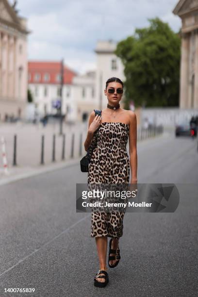 Celine Bethmann wearing Versace Jeans couture black gold sandals, Zara animal print dress, Bottega Veneta shades and Balenciaga Le Cagole black bag...