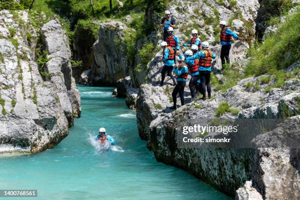 freunde, die am rand der klippe stehen - swim safety stock-fotos und bilder