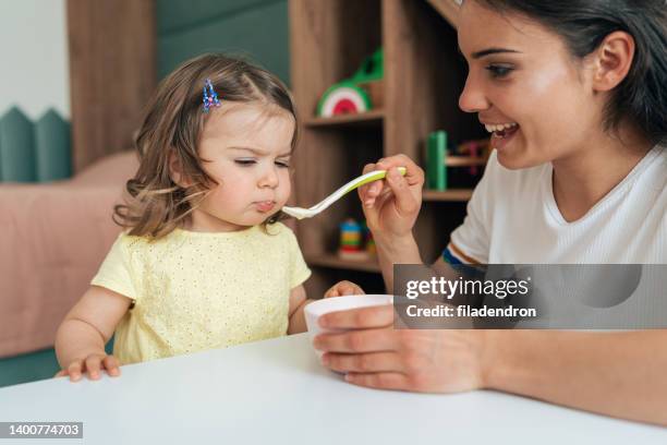 mother feeding her girl - picky eater stock pictures, royalty-free photos & images
