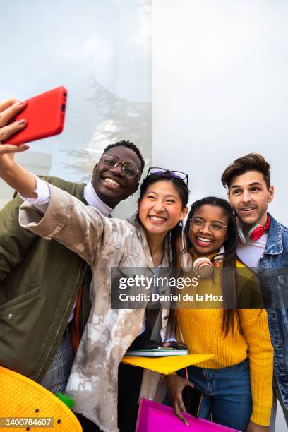 happy multiracial college students take selfie with mobile phone laughing and having fun outside university building. vertical image. copy space. - friend group selfie stock pictures, royalty-free photos & images