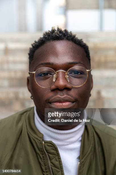 headshot of confident african american teen college student with eyeglasses looking at camera. vertical image. - studio head shot serious confident looking at camera foto e immagini stock
