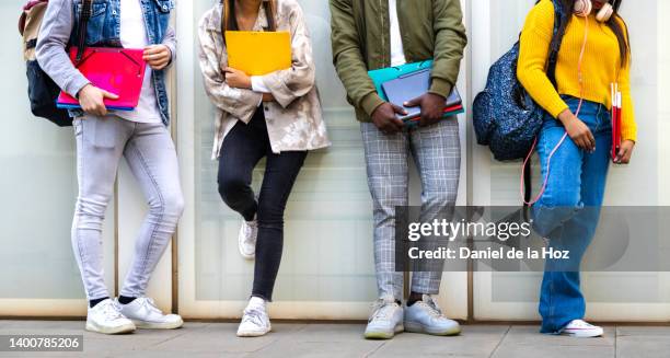 group of multiracial teenage college students ready to go back to school standing against blue background wall. - boy jeans stockfoto's en -beelden