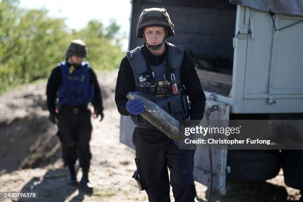 Bomb disposal experts from the Ukrainian State Emergency Service prepare for a controlled explosion of 1 ton of unexploded missiles, artillery shells...