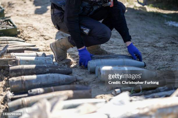 Bomb disposal experts from the Ukrainian State Emergency Service prepare for a controlled explosion of 1 ton of unexploded missiles, artillery shells...