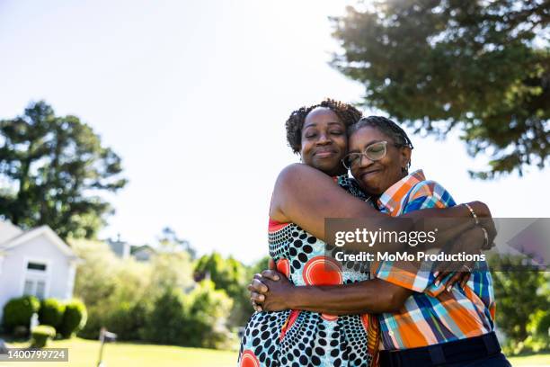 lesbian couple embracing outdoors in suburban neighborhood - black population stock pictures, royalty-free photos & images
