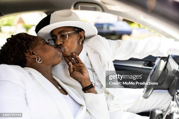 lesbian couple in white suits riding in automobile - black lesbians kiss stock pictures, royalty-free photos & images