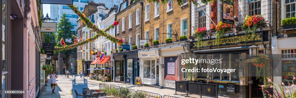 London Covent Garden shops pubs garlanded with flowers summer panorama