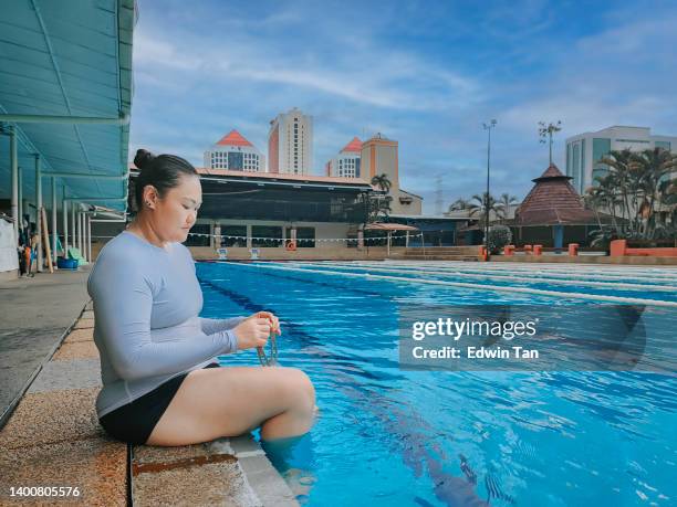 asian chinese woman wearing swimming goggle before entering into swimming pool - woman swimsuit happy normal stock pictures, royalty-free photos & images
