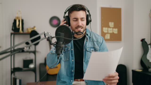 Young hispanic man singing song at music studio