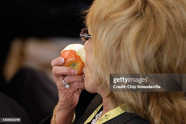 Arizona Gov. Jan Brewer snacks on an apple while Vice President Joe Biden addresses a meeting of the National Governors Association in the State...