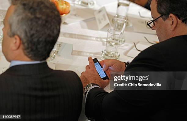 New Jersey Gov. Chris Christie looks at his email while First Lady Michelle Obama during a meeting of the National Governors Association in the State...