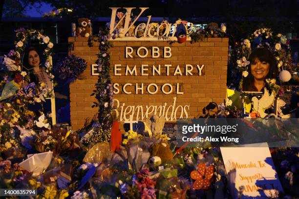 Flowers and photographs are seen at a memorial dedicated to the victims of the mass shooting at Robb Elementary School on June 3, 2022 in Uvalde,...