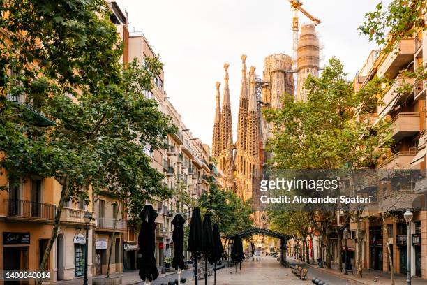 sagrada familia and street in barcelona, catalonia, spain - sagrada familia barcelona stock pictures, royalty-free photos & images