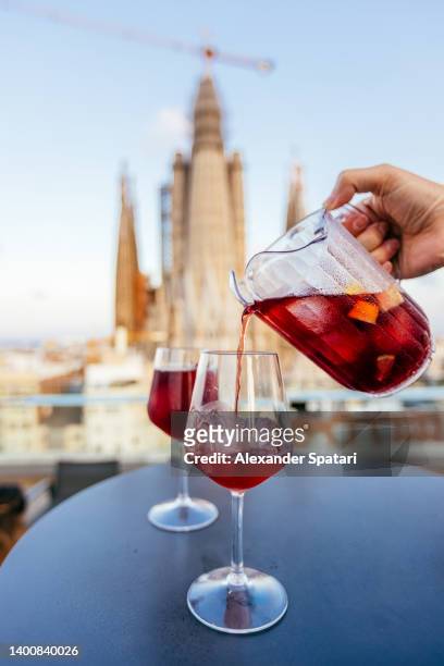man pouring sangria drink from the jar to the glass, close-up - sangria stockfoto's en -beelden