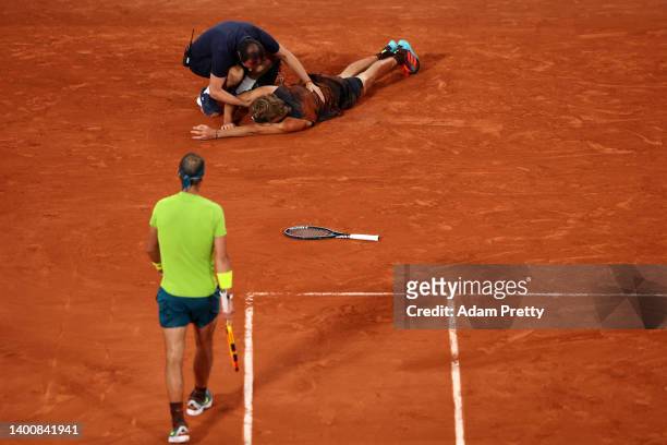 Rafael Nadal of Spain walks to Alexander Zverev of Germany as he receives medical attention following an injury against Rafael Nadal of Spain during...