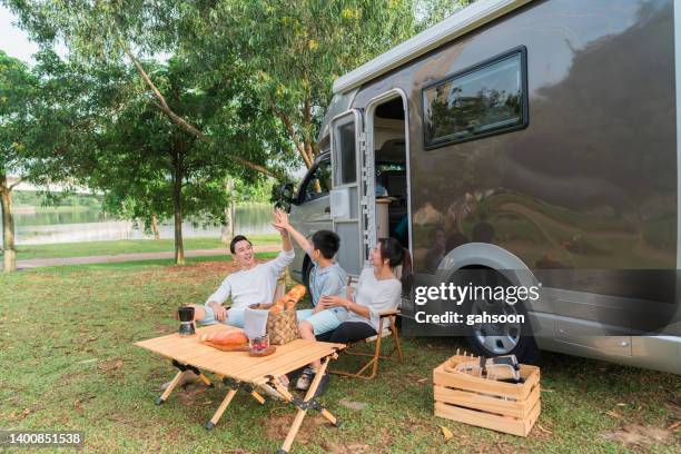 family high five in front of motor home holidays - family caravan stock pictures, royalty-free photos & images