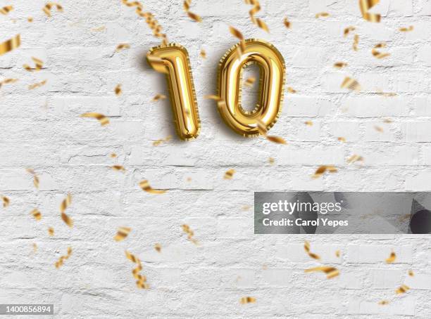 10 foil golden ballon in gold background - number 10 stock pictures, royalty-free photos & images