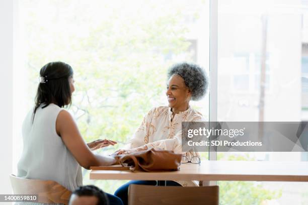 female co-workers meet in coffee shop - elderly cognitive stimulation therapy stockfoto's en -beelden