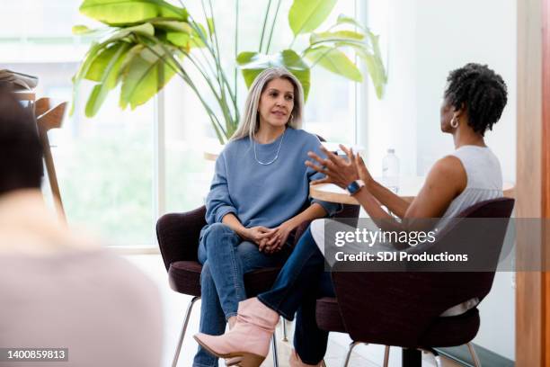 diverse donne adulte mature si incontrano al bar per chattare - friends chatting mature foto e immagini stock