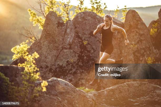 starke frau läuft am berg - sportlerin stock-fotos und bilder