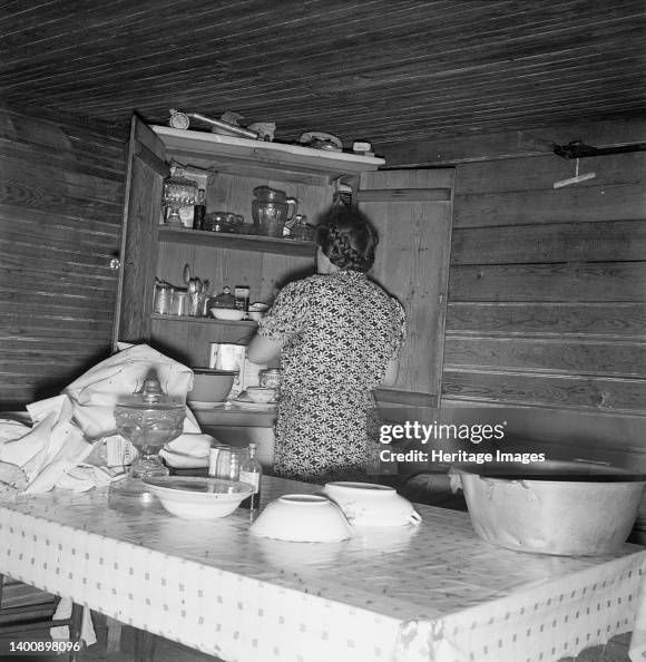 Wife Of Tobacco Sharecropper Putting Breakfast Dishes Away. Person County