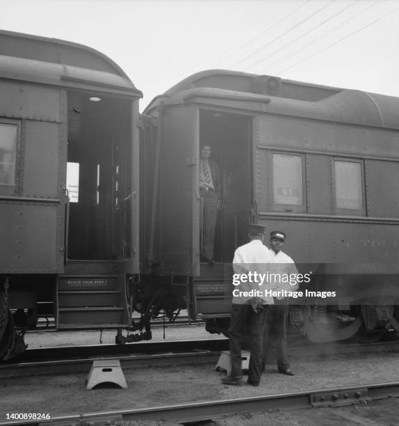 Railroad yards, Kearney, Nebraska. Overland train passengers go back to their cars after ten minute train stop on trip between San Francisco and...