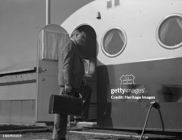 The doctor arrives in camp by previous appointment with the nurse. Seen entering the mobile trailer clinic at FSA mobile camp. Merrill, Klamath...