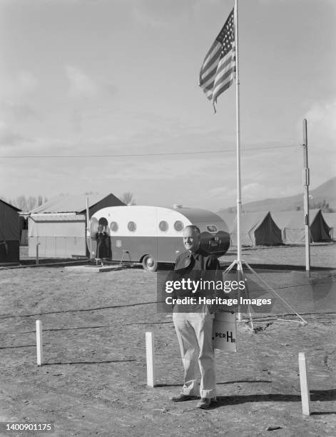 The camp manager at camp entrance. Merrill, Klamath County, Oregon. FSA . Clinic trailer shown beyond. Artist Dorothea Lange.